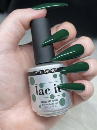 en Vogue Lac it! Fifth Avenue green UV/LED gel polish for professional nails and extensions shown on stiletto nails holding polish bottle