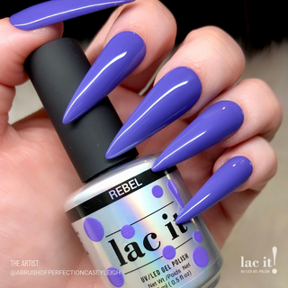 en Vogue Lac It! Rebel deep periwinkle crème UV/LED gel nail polish for professional nails and extensions on long stiletto manicured nails holding polish bottle