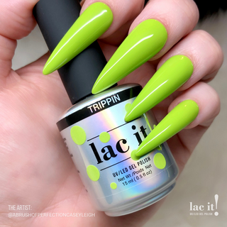 en Vogue Lac It! Trippin vibrant chartreuse-green crème UV/LED gel nail polish for professional nails and extensions on long stiletto shaped manicured nails holiding polish bottle